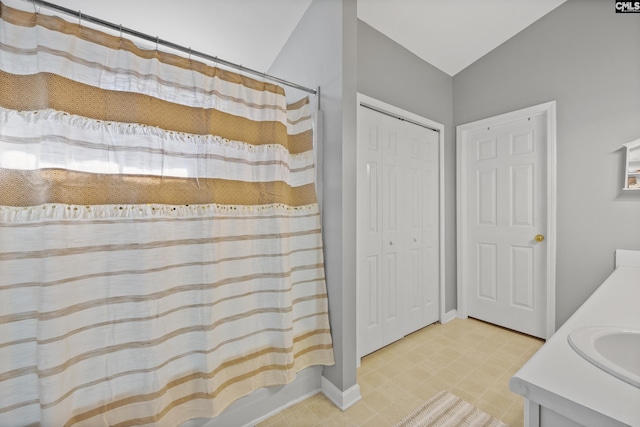 bathroom with curtained shower, vaulted ceiling, and vanity