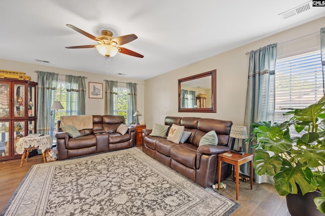 living room featuring wood-type flooring and ceiling fan