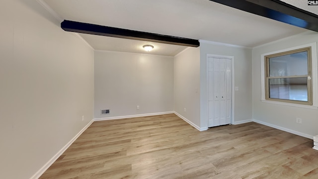 unfurnished room featuring beamed ceiling, crown molding, and light hardwood / wood-style floors