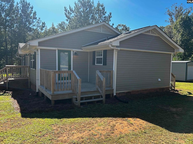 back of house featuring a storage shed, a yard, and a deck