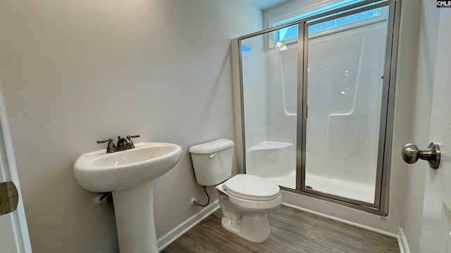 bathroom featuring toilet, a shower with shower door, wood-type flooring, and sink