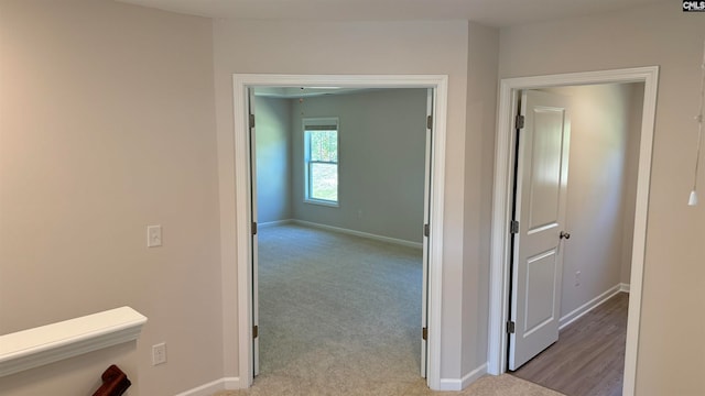 corridor featuring light colored carpet