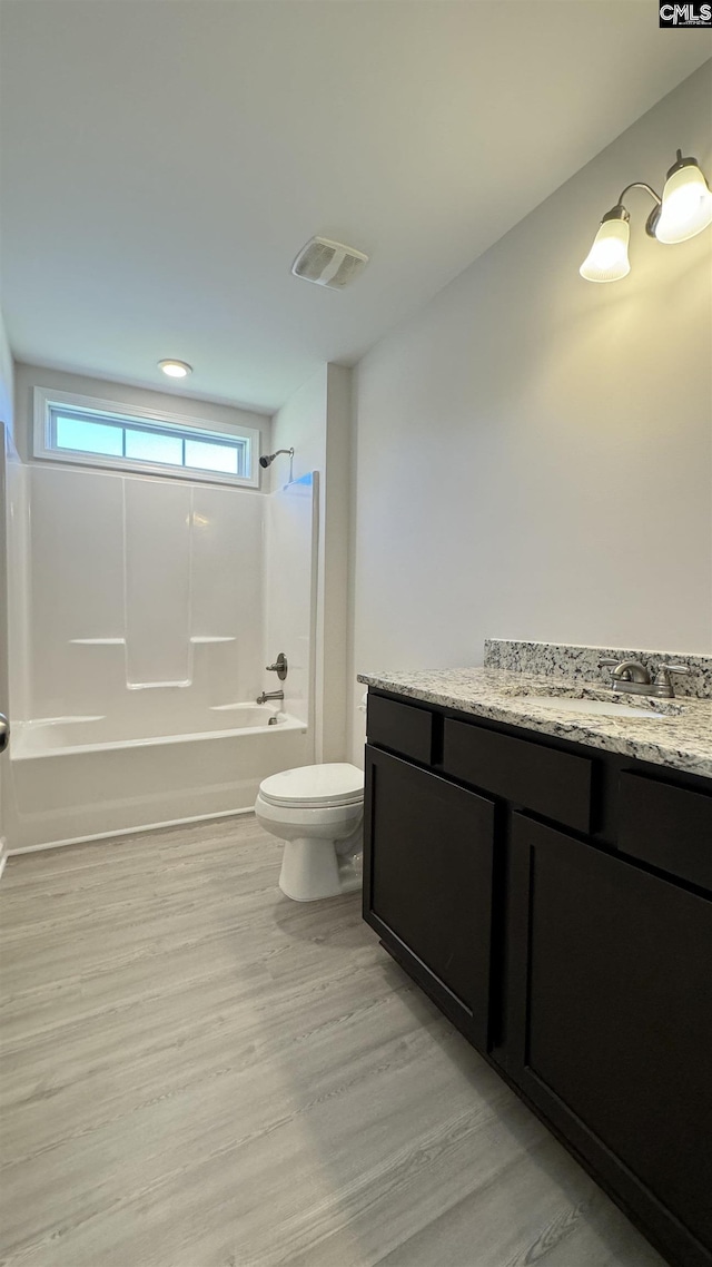 full bathroom with toilet, bathing tub / shower combination, wood-type flooring, and vanity