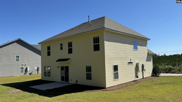 rear view of house with a lawn and a patio