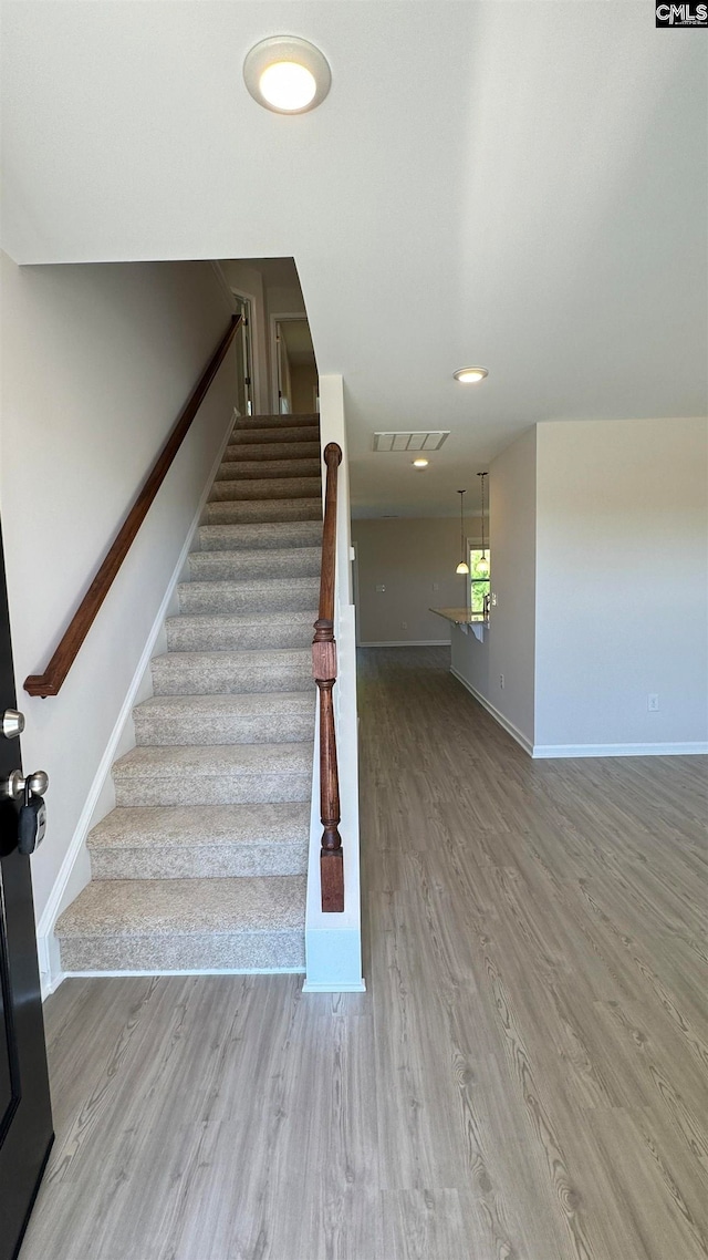 stairway featuring wood-type flooring