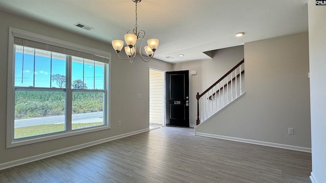 unfurnished room with dark wood-type flooring and a chandelier