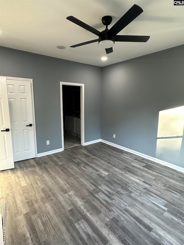 unfurnished bedroom with ceiling fan, ensuite bathroom, and dark hardwood / wood-style floors