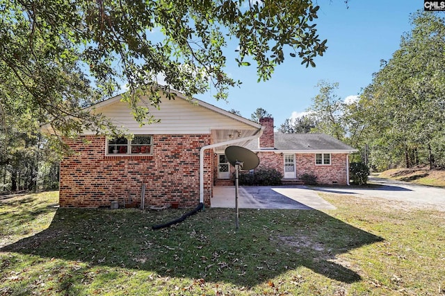 886 Polson Rd, Camden, SC 29020 - view of front of property featuring a front lawn, a patio, a chimney, brick siding, and driveway