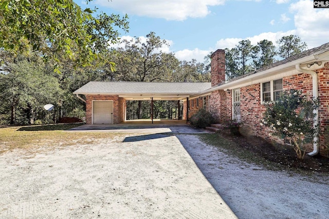 886 Polson Rd, Camden, SC 29020 - view of front of house featuring an attached garage, brick siding, a chimney, and dirt driveway