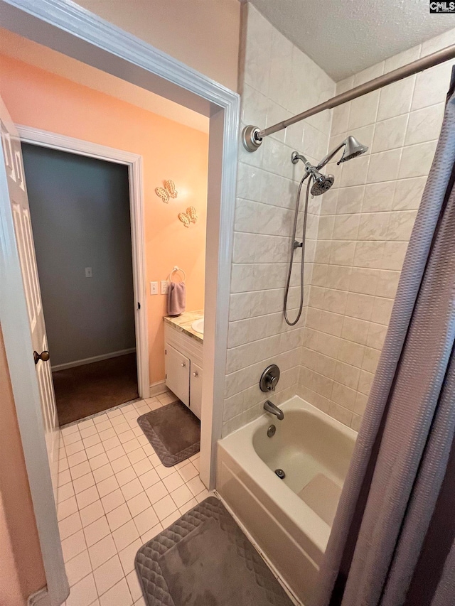 bathroom featuring tile patterned flooring, shower / tub combo, vanity, and a textured ceiling