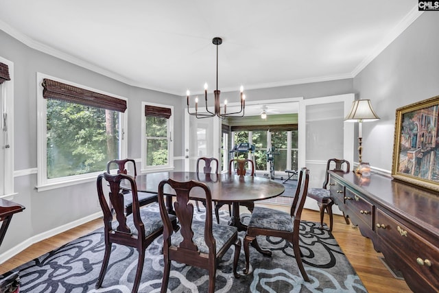 dining area with hardwood / wood-style flooring, crown molding, and a chandelier