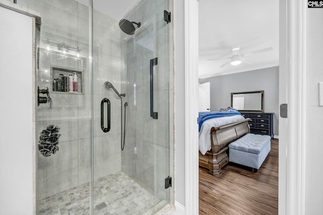 bathroom with a shower with door, hardwood / wood-style flooring, and ceiling fan