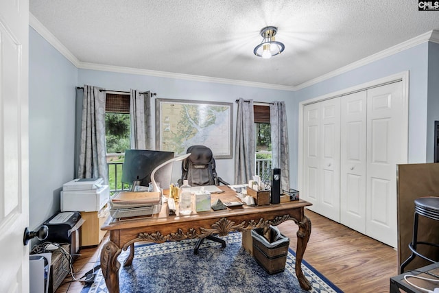 office area with wood-type flooring, a textured ceiling, ornamental molding, and a wealth of natural light