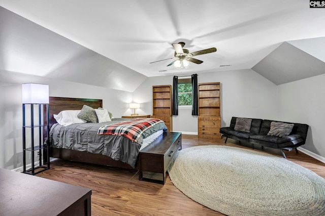 bedroom with dark hardwood / wood-style floors, vaulted ceiling, and ceiling fan