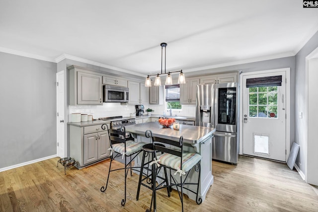 kitchen featuring gray cabinetry, a center island, stainless steel appliances, and light hardwood / wood-style flooring