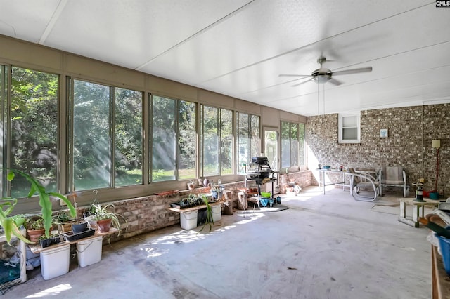 unfurnished sunroom with ceiling fan