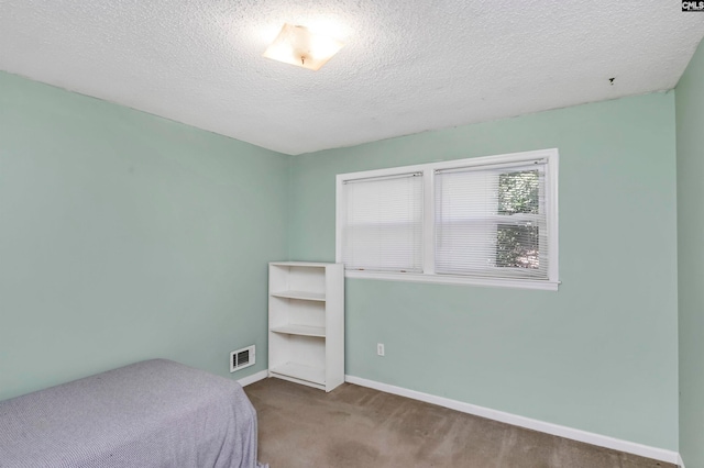 carpeted bedroom featuring a textured ceiling