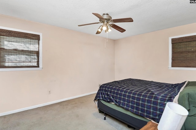 bedroom with light colored carpet, a textured ceiling, and ceiling fan