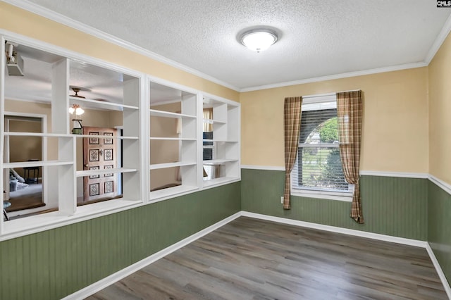 unfurnished room with ornamental molding, hardwood / wood-style flooring, and a textured ceiling