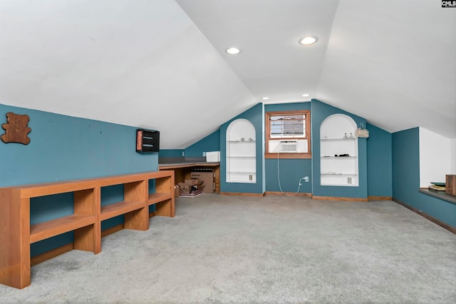 bonus room with built in features, vaulted ceiling, and light carpet