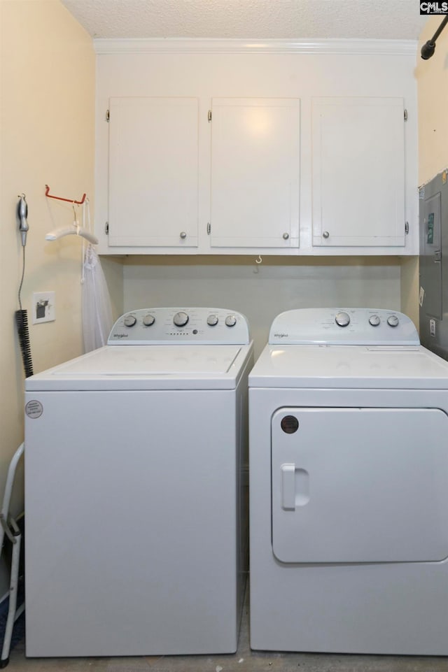 clothes washing area with electric panel, a textured ceiling, cabinets, independent washer and dryer, and crown molding