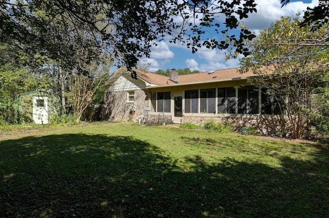 view of yard featuring a sunroom and a storage unit