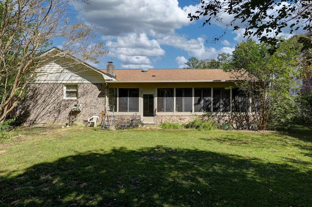 rear view of property with a yard and a sunroom