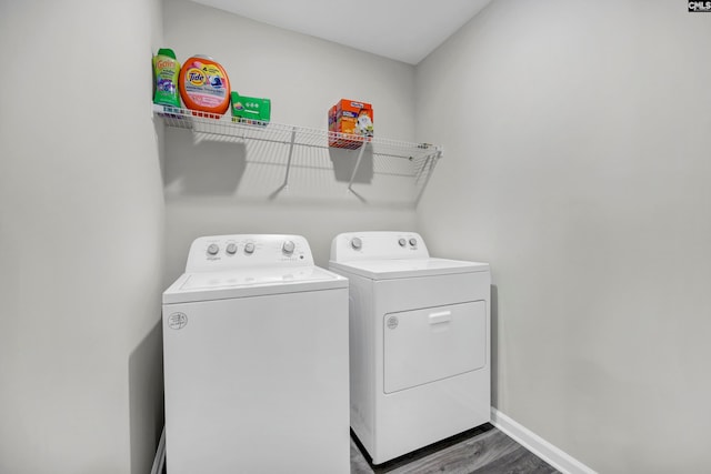 laundry area with separate washer and dryer and dark wood-type flooring