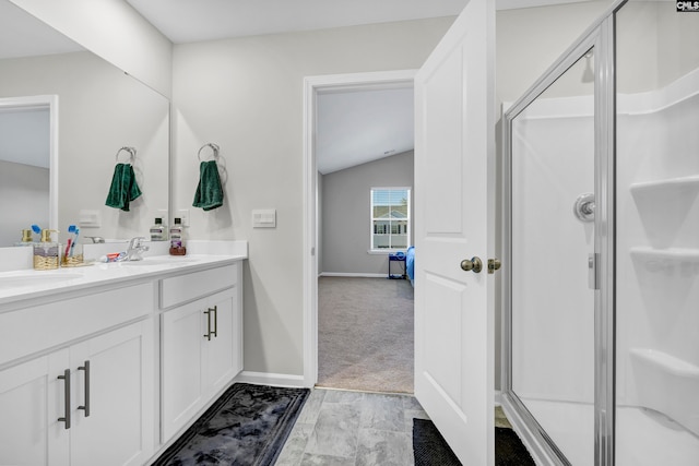 bathroom with vanity, vaulted ceiling, and an enclosed shower