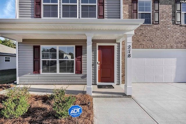 property entrance with a garage and covered porch