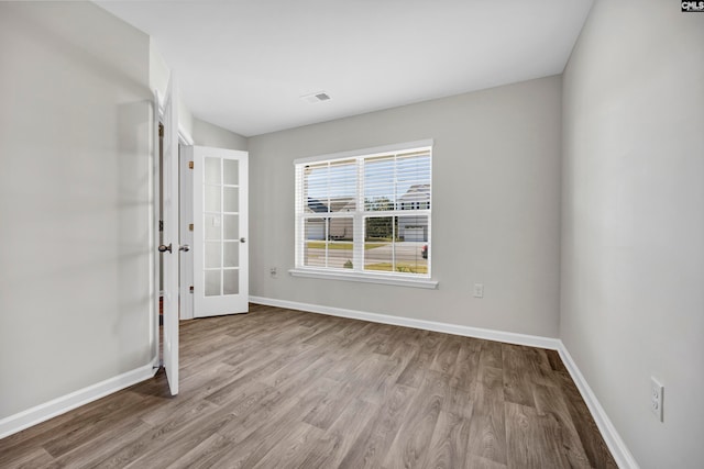 spare room with french doors and light hardwood / wood-style floors