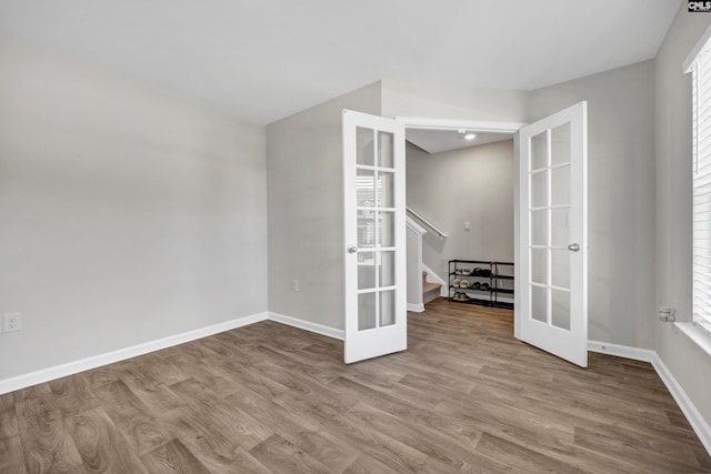 unfurnished room with plenty of natural light, french doors, and light wood-type flooring