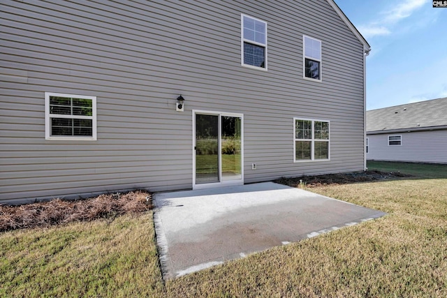 rear view of house with a lawn and a patio area