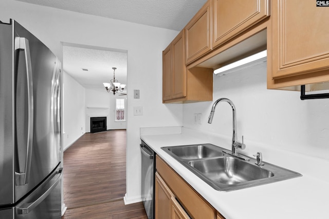 kitchen featuring appliances with stainless steel finishes, dark hardwood / wood-style flooring, sink, and a textured ceiling