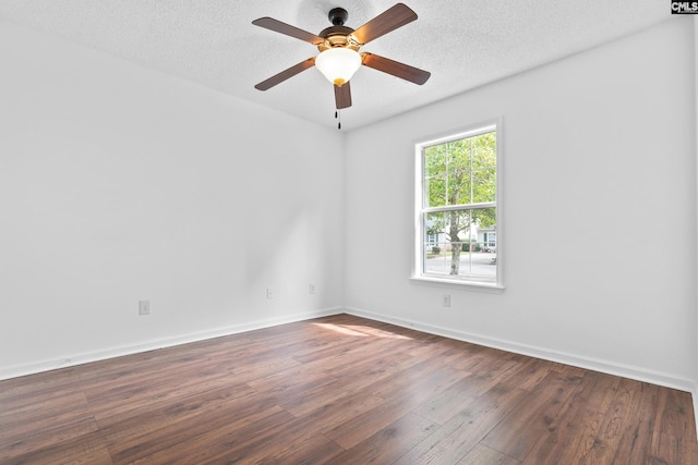 empty room with ceiling fan, dark hardwood / wood-style floors, and a textured ceiling