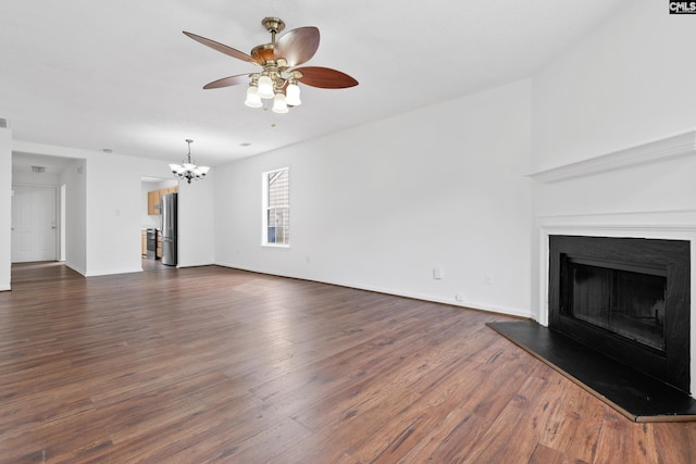 unfurnished living room featuring dark hardwood / wood-style flooring and ceiling fan with notable chandelier