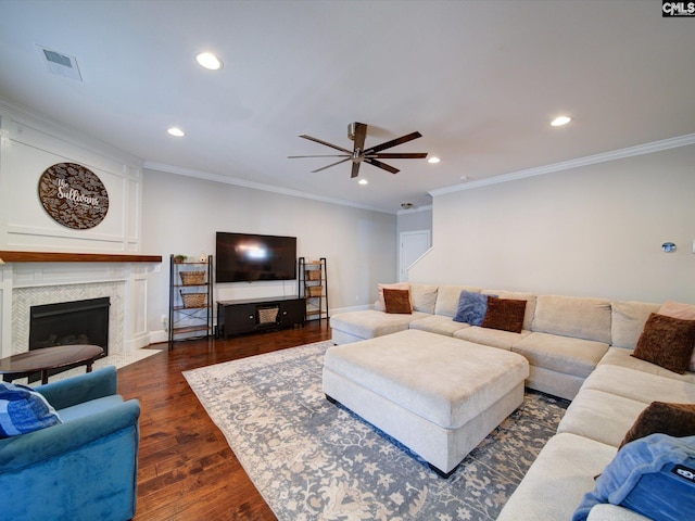 living room with crown molding, ceiling fan, and dark wood-type flooring