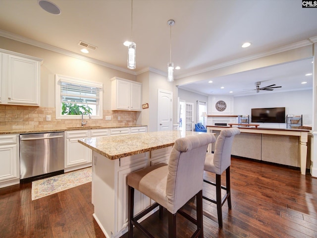 kitchen with dark wood-type flooring, white cabinets, decorative light fixtures, and stainless steel dishwasher