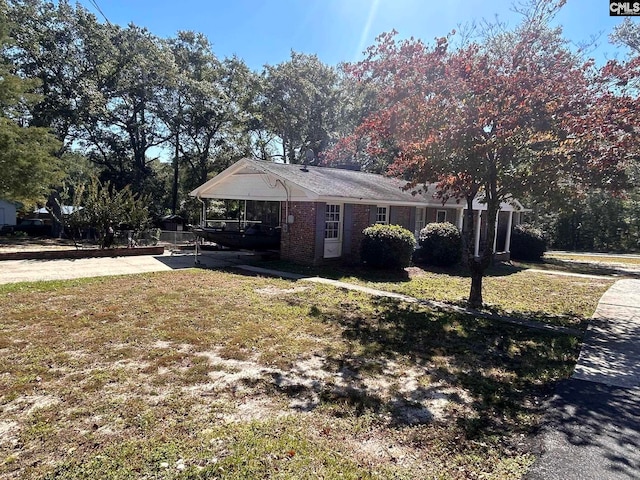 view of front of house featuring a carport and a front lawn