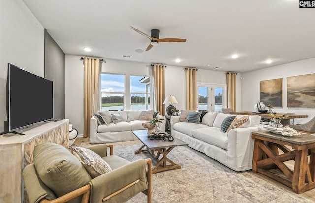 living room featuring light hardwood / wood-style floors, a wealth of natural light, and ceiling fan