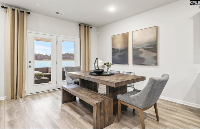 dining room with a water view and light wood-type flooring