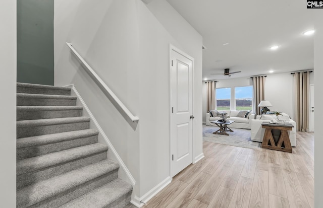 stairway with ceiling fan and hardwood / wood-style floors