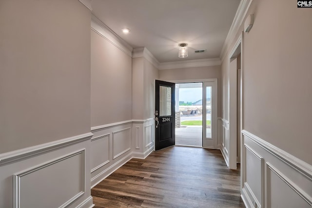 doorway with ornamental molding and dark hardwood / wood-style floors