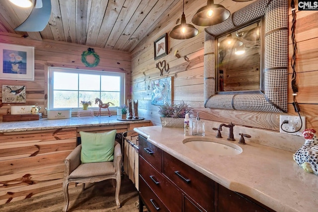 bathroom featuring wood walls, wood ceiling, and vanity