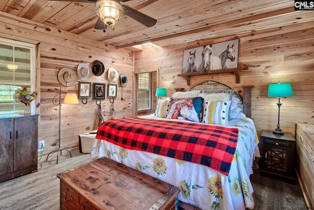 bedroom featuring hardwood / wood-style flooring, ceiling fan, wood walls, and wooden ceiling