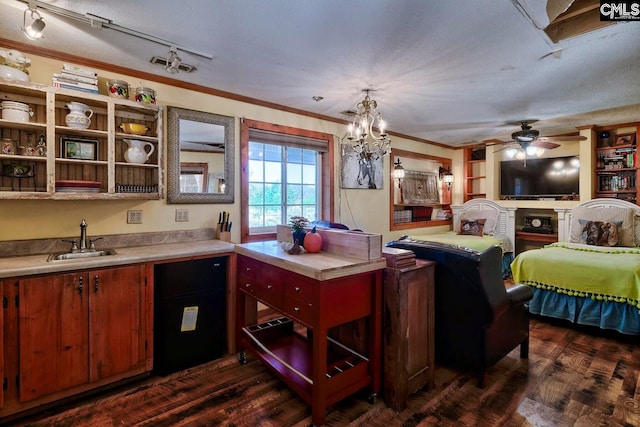 kitchen with crown molding, dark wood-type flooring, sink, and a textured ceiling