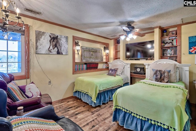 bedroom with ceiling fan, crown molding, hardwood / wood-style flooring, and a textured ceiling