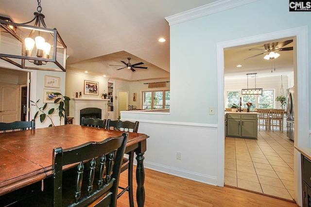 dining space with an inviting chandelier, crown molding, and light hardwood / wood-style flooring