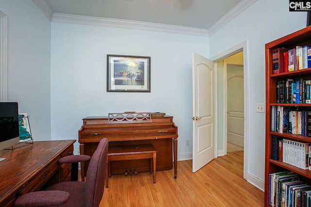 home office with ornamental molding and light hardwood / wood-style flooring