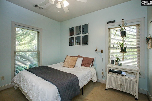 carpeted bedroom featuring ceiling fan and multiple windows